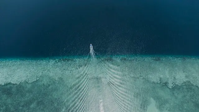 An aerial shot of a boat going out to sea